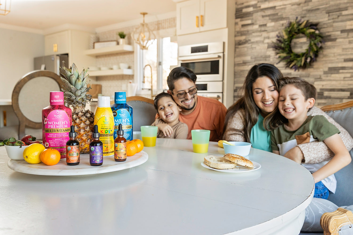 A family with young kids next to Tropical Oasis liquid vitamins on a table